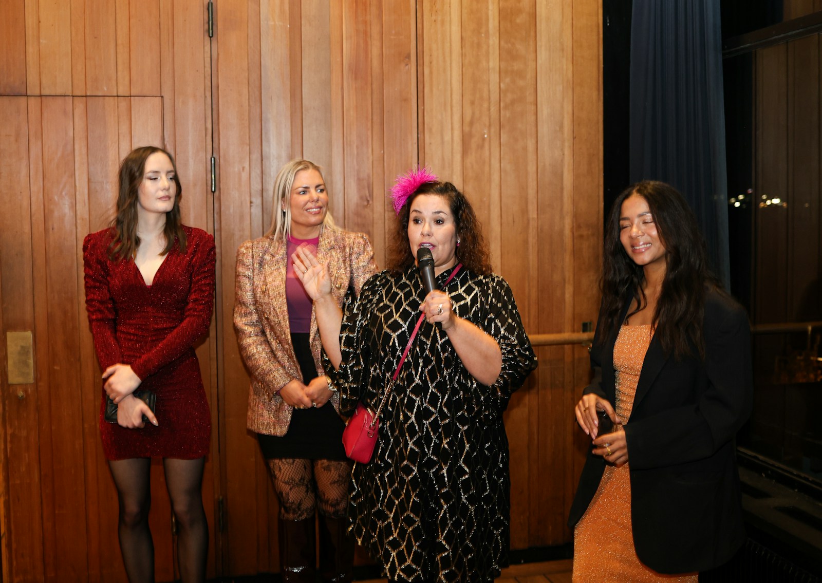 A woman speaking into a microphone among a group of women